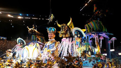 Grande desfile com muitas pessoas vestindo trajes coloridos